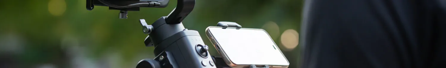 En man håller en gimbal med en systemkamera.